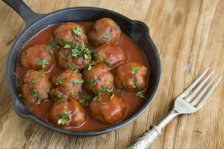 Albondigas (Fleischbällchen) in Tomatensauce mit Petersilie in kleiner gußeiserner Pfanne mit Gabel.. Nach Originalrezept von Papa Corazón Catering, Rhein-Main-Gebiet.