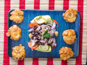Arroz congris mit Platanos und Salat auf blau-weiß-roter Dekoration