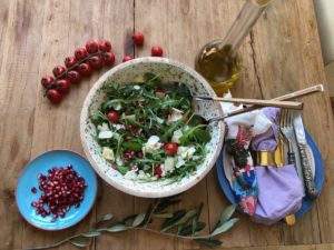 Rucola Salat mit Granatapfel, Mozzarella, Nüssen und Parmesan in feierlicher Schale mit goldenem Salatbesteck, eine Kreation von Papa Corazón Catering aus Oberursel, bei Bad Homburg