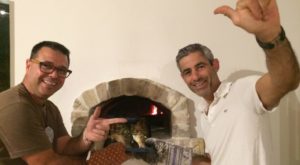 Zwei Köche von Papa Corazon lachen vor einem Steinbackofen