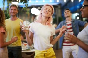 Frau tanzt auf Gartenparty